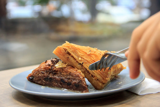 Juicy baklava with crispy layers, served on a plate with a golden finish.