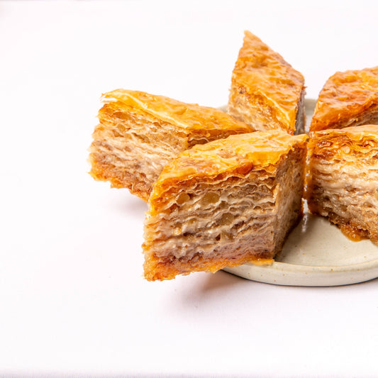 Freshly made baklava with golden layers of phyllo and sweet syrup.